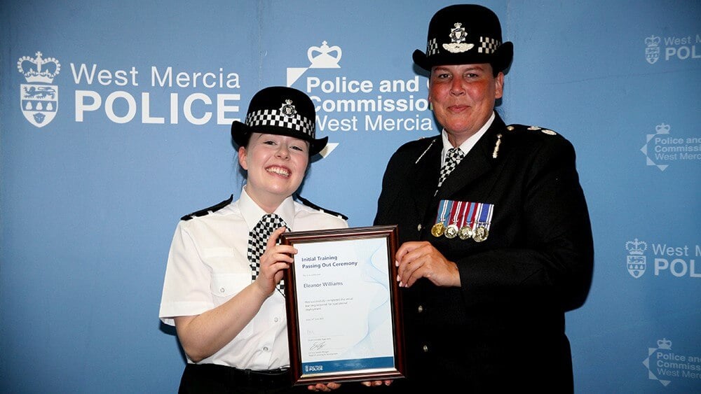 PC Ellie Williams receiving a certificate from a fellow officer at an event.