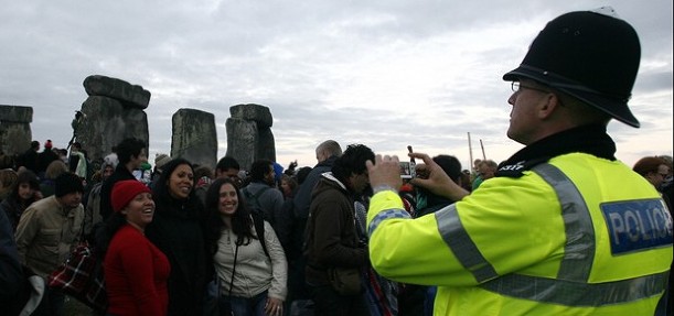 Police officer with crowd at Stonehenge.