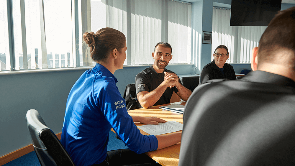 A group of officers in a meeting room.