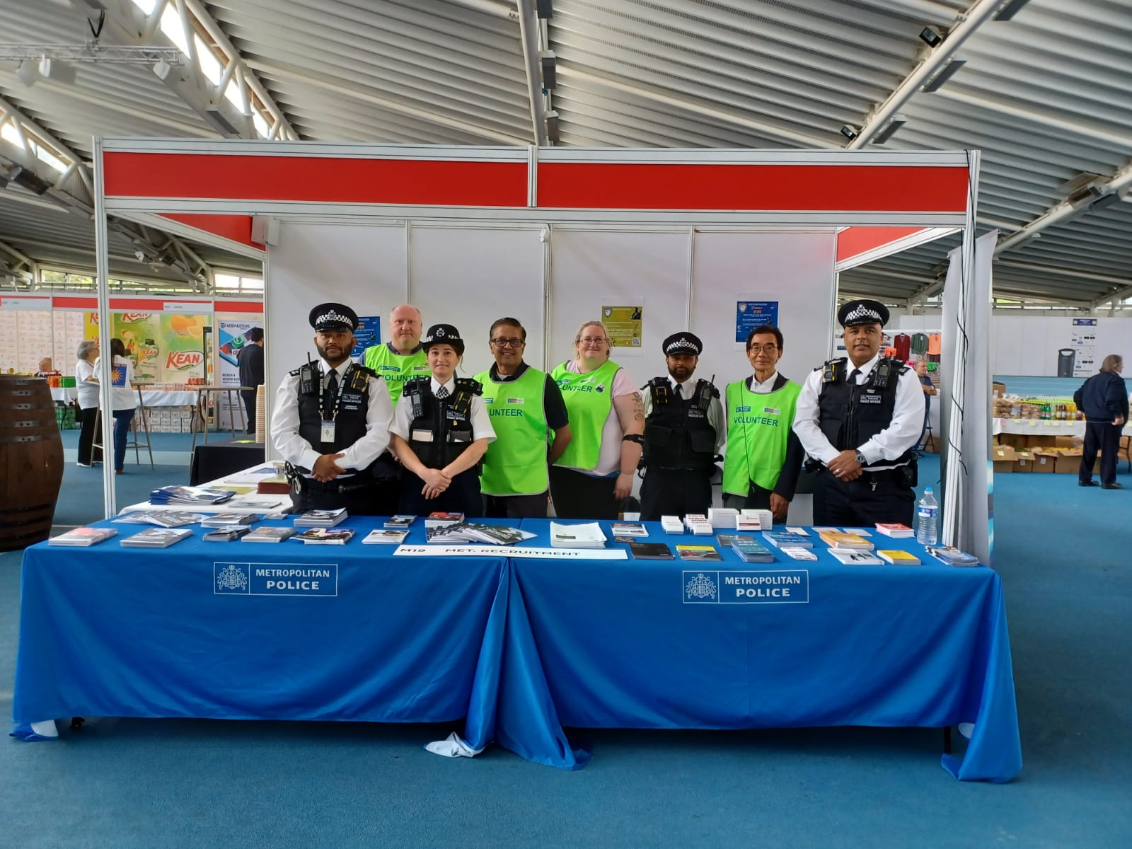 A team of Metropolitan Police officers standing on their recruitment stand inside a shopping centre.